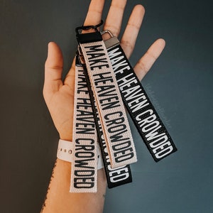 May include: Three keychains with the text "Make Heaven Crowded" in white lettering on a black and beige background.