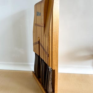 May include: Wooden knife block with a set of knives. The block is made of light wood with dark wood accents. The knives are all metal with brown handles.