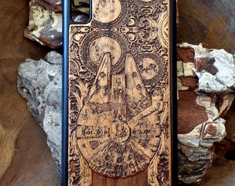 May include: A wooden phone case with a laser-engraved design of the Millennium Falcon from Star Wars. The case is brown with a black border and has a detailed design of the spaceship.