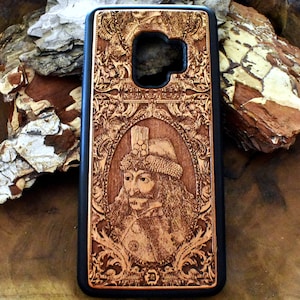 May include: A wooden phone case with a detailed engraving of a historical figure with a beard and a crown. The case is brown with a black border and a camera cutout.