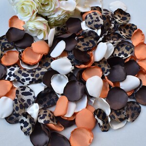 Può includere: Un mix di petali di rosa in tessuto marrone, bianco e arancione con un motivo leopardato.