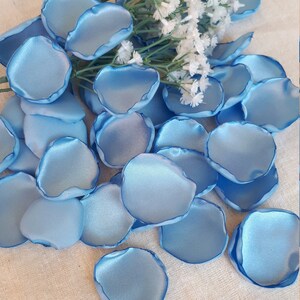 May include: A pile of light blue satin rose petals, perfect for wedding decorations or special events.