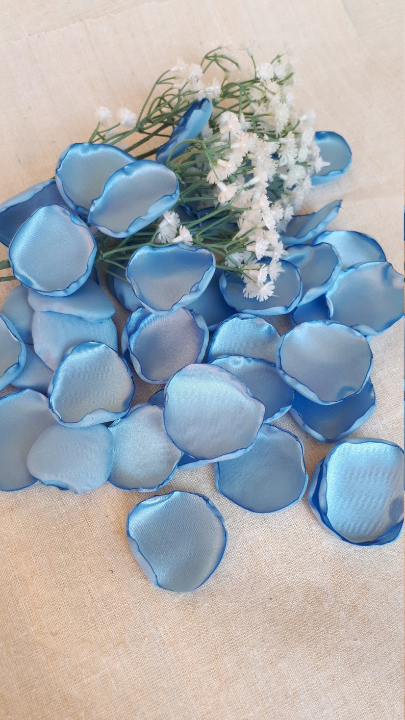 May include: A pile of light blue satin rose petals, perfect for wedding decorations or special events.
