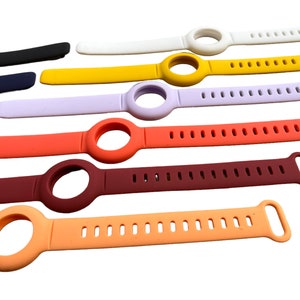 K&ouml;nnte beinhalten: Sortiment an bunten Silikon-Uhrenarmb&auml;ndern mit einer runden &Ouml;ffnung f&uuml;r ein Zifferblatt. Die Armb&auml;nder haben ein strukturiertes Design mit kleinen L&ouml;chern.
