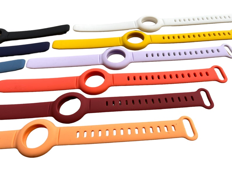 K&ouml;nnte beinhalten: Sortiment an bunten Silikon-Uhrenarmb&auml;ndern mit einer runden &Ouml;ffnung f&uuml;r ein Zifferblatt. Die Armb&auml;nder haben ein strukturiertes Design mit kleinen L&ouml;chern.