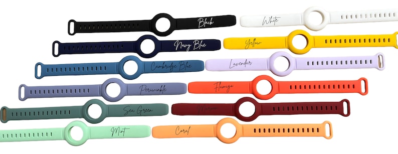K&ouml;nnte beinhalten: Ein Set mit 14 Silikon-Uhrenarmb&auml;ndern in verschiedenen Farben, darunter Schwarz, Wei&szlig;, Marineblau, Gelb, Cambridge-Blau, Lavendel, Periwinkle, Flamingo, Seegr&uuml;n, Minze, Koralle und Orange. Jedes Armband hat eine kreisf&ouml;rmige &Ouml;ffnung f&uuml;r ein Zifferblatt.