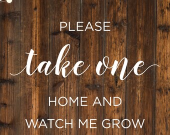 May include: A rustic wooden sign with white string lights hanging above the text "PLEASE take one HOME AND WATCH ME GROW".