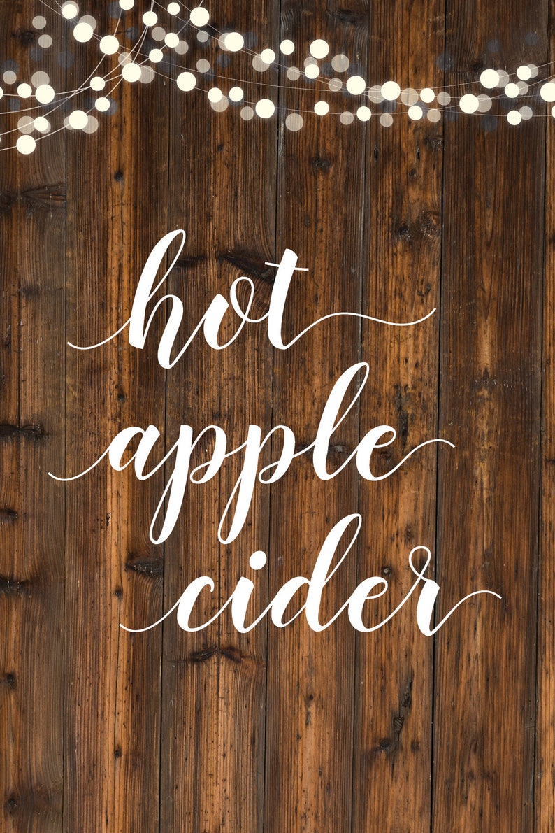 Puede incluir: Un fondo de madera r&uacute;stico con una cadena de luces blancas colgando en la parte superior. Las palabras "hot apple cider" est&aacute;n escritas en cursiva blanca.