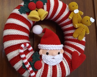 May include: A red and white striped crocheted wreath with a Santa Claus face, two gingerbread people, candy canes, holly, and bells.