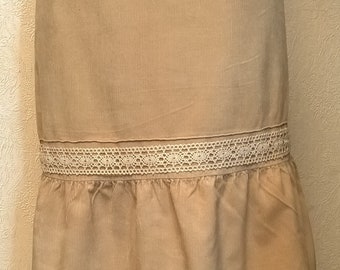 May include: A beige corduroy skirt with a lace trim. The skirt has a ruffled bottom and a frayed hem.