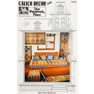 May include: A quilt pattern for a Bear Paw Bedroom, featuring a quilt with a bear paw design in brown, blue, and tan. The pattern is from Calico Decor, That Patchwork Place, and is number D600.