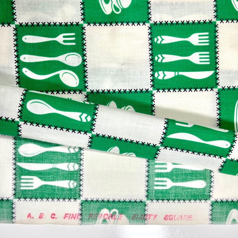 May include: White and green fabric with a repeating pattern of kitchen utensils. The design features forks, spoons, and knives in white against green squares, with black stitching. The text "A. B. C. FINE PICKLE EIGHTY SQUARE" is visible.