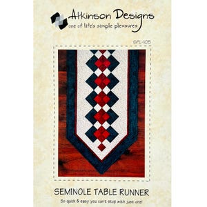 May include: A sewing pattern for a Seminole table runner. The pattern features a red, white, and blue geometric design. The pattern is titled "Seminole Table Runner" and includes the text "So quick & easy you can't stop with just one!"