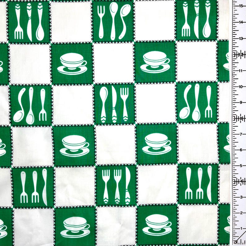 May include: White and green checkered fabric with a repeating pattern of kitchen utensils and teacups. The design features white forks, spoons, knives, and teacups on a green background, stitched with black thread, alternating with white squares.