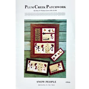 May include: A Plum Creek Patchwork pattern titled Snow People Bringing in the Tree #3046. The cover features four quilted projects with applique snow people, stars, moons, and trees in cream, red, and brown plaid fabrics on a green wood background.