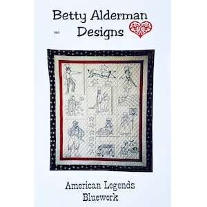 May include: A quilted wall hanging with the text "Betty Alderman Designs" and "American Legends Bluework." The quilt features embroidered images of historical figures and symbols, with a red and navy border.