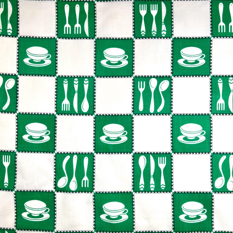 May include: A white and green checkered pattern fabric featuring alternating squares. Green squares display white teacups, forks, spoons, and knives. The fabric has a stitched border, creating a vintage, retro aesthetic.