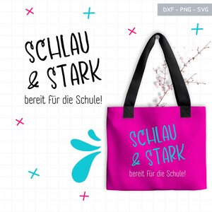 May include: A vibrant pink tote bag with black handles displays the words "SCHLAU & STARK" in blue, and "bereit für die Schule!" in white. The design includes teal splashes and decorative crosses.