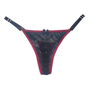May include: Black lace underwear with a red trim and black bow detail.