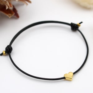 schwarzes Lederarmband mit goldfarbenem Herz