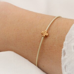 Lederarmband in creme mit Kreuz rosegold am Handgelenk getragen