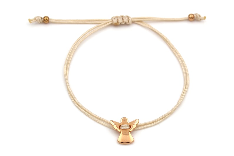 beiges Armband mit rosegoldfarbenem Schutzengel auf weißem Hintergrund