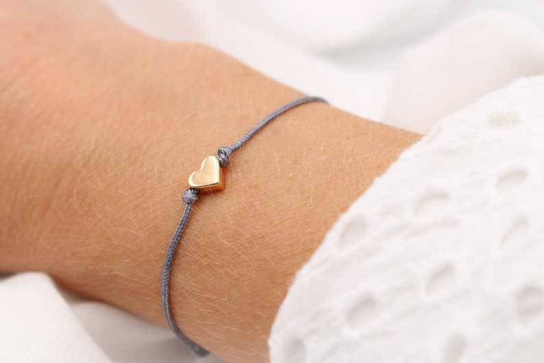 graues Armband Herz rosegold farben, Makrameearmband am Handgelenk getragen