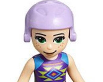 Puede incluir: Una minifigura Lego con el pelo morado, que lleva un top sin mangas con estampado azul y morado, pantalones cortos marrones y zapatos naranjas.