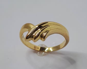 Op de afbeelding: Een gouden ring met een uniek, golvend ontwerp. De ring is aan de binnenkant gemarkeerd met "10K".