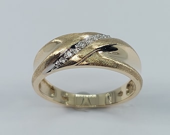 May include: A gold band with a brushed finish and a row of small diamonds set in a diagonal line.