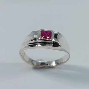 Peut inclure: Une bague en argent avec une pierre précieuse rose vif de forme carrée.