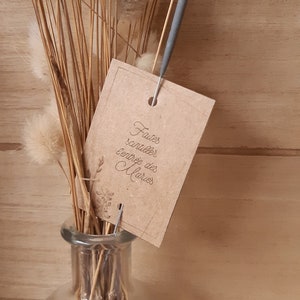 Peut inclure: Une étiquette en papier kraft avec le texte "Faites scintiller l'entrée des Mariés" attachée à un bouquet de pampas séchées dans un vase en verre transparent.