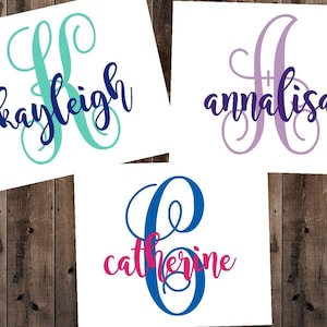 May include: Three white canvases with a decorative monogram letter and name in different colours. The first canvas has a teal K with the name "kayleigh" in navy blue. The second canvas has a purple A with the name "annalisa" in navy blue. The third canvas has a blue C with the name "catherine" in pink.