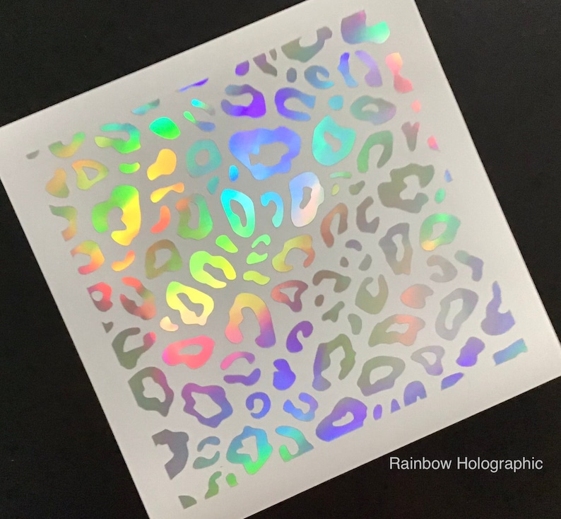 May include: A sheet of rainbow holographic vinyl with a leopard print pattern. The vinyl is white with a rainbow iridescent finish.