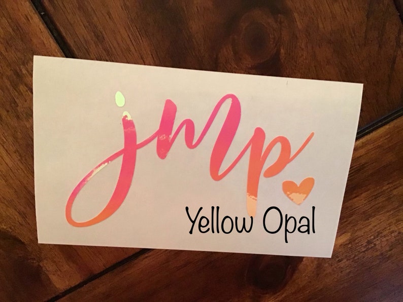 May include: A pink and orange iridescent vinyl decal with the word "jump" in cursive lettering and a small heart. The text "Yellow Opal" is printed below the word "jump".