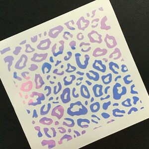 May include: A white sheet of paper with a pink and blue leopard print design. The print is a gradient, with pink at the top and blue at the bottom.