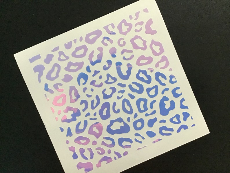 May include: A white sheet of paper with a pink and blue leopard print design. The print is a gradient, with pink at the top and blue at the bottom.