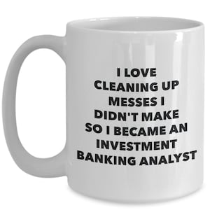 May include: White ceramic coffee mug with black text that reads: "I love cleaning up messes I didn't make so I became an investment banking analyst."