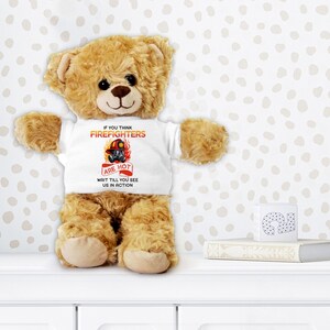 May include: A brown teddy bear wearing a white t-shirt with the text "If you think firefighters are hot, wait till you see us in action".