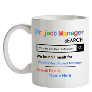 May include: White ceramic mug with a Google search bar design. The text reads "Project Manager Search" and "We found 1 result for World's Best Project Manager". The search result is "Name Here".