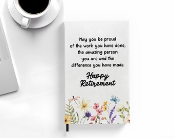 May include: A white journal with a floral design and the text "May you be proud of the work you have done, the amazing person you are and the difference you have made. Happy Retirement."