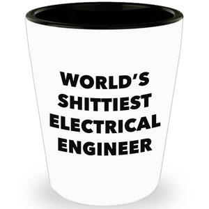 May include: White ceramic shot glass with a black rim. The glass has the text "WORLD'S SHITTIEST ELECTRICAL ENGINEER" printed in black.