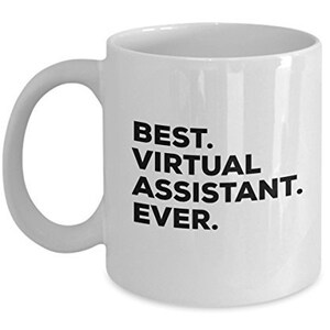 Pode incluir: Caneca de café de cerâmica branca com uma inscrição preta que diz "Best. Virtual Assistant. Ever."