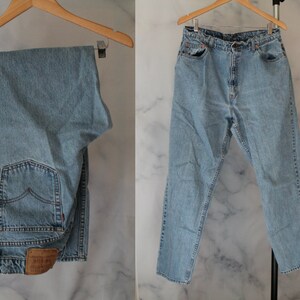 May include: A pair of light blue denim jeans with a brown leather patch on the back pocket.