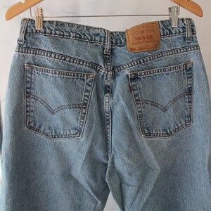 Puede incluir: Un par de pantalones vaqueros de mezclilla azul claro con un parche de la marca Levi's en el bolsillo trasero. Los pantalones tienen dos bolsillos traseros y cierre de bot&oacute;n.