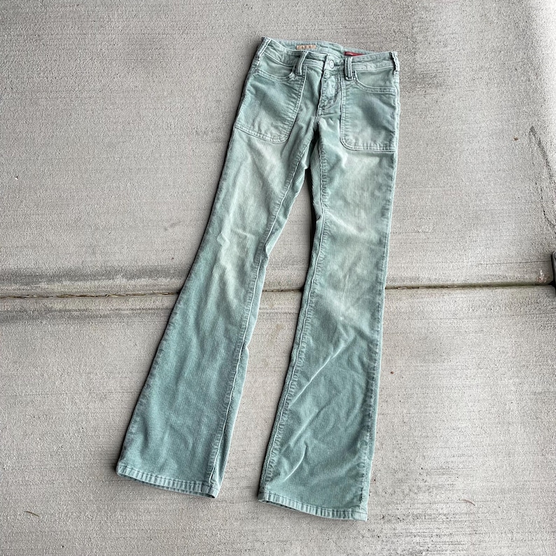 May include: A pair of light green corduroy bell bottom pants with a button fly and two patch pockets on the front.