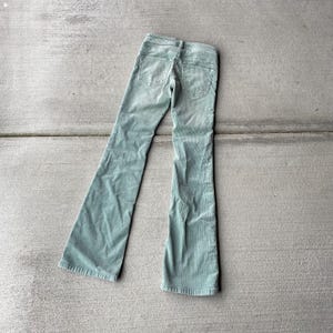 May include: A pair of light green corduroy pants with a wide leg and a high waist.