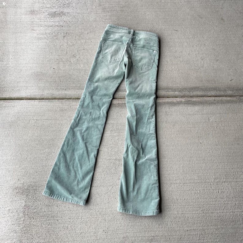 May include: A pair of light green corduroy pants with a wide leg and a high waist.