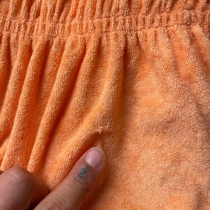 Pode incluir: Close-up de um tecido de toalha cor de p&ecirc;ssego com uma superf&iacute;cie texturizada.
