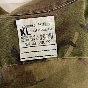 Może przedstawiać: Biała metka z czarnym tekstem, kt&oacute;ry brzmi "Lonneker textiles KL 872.2660.7613.18.90 NATO MAAT: 8000/9500 50% KATOOEN 50% POLYESTER" z symbolami instrukcji prania.